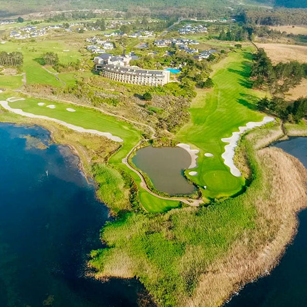 Golf course with a lake and clubhouse in the background