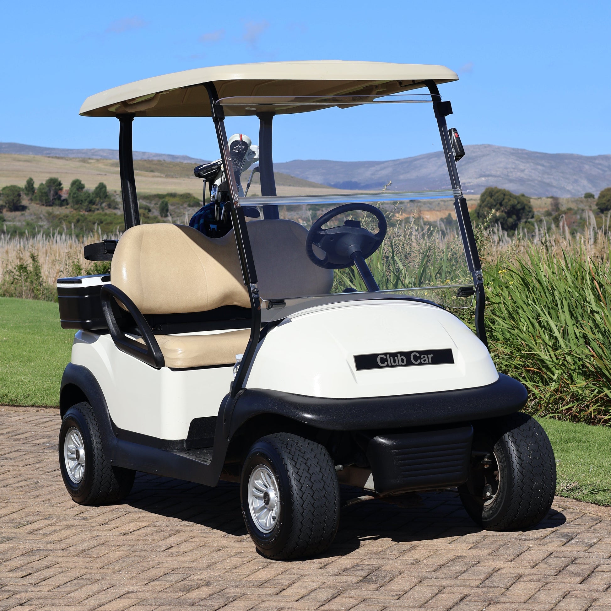 Golf cart on a golf course with a clear blue sky